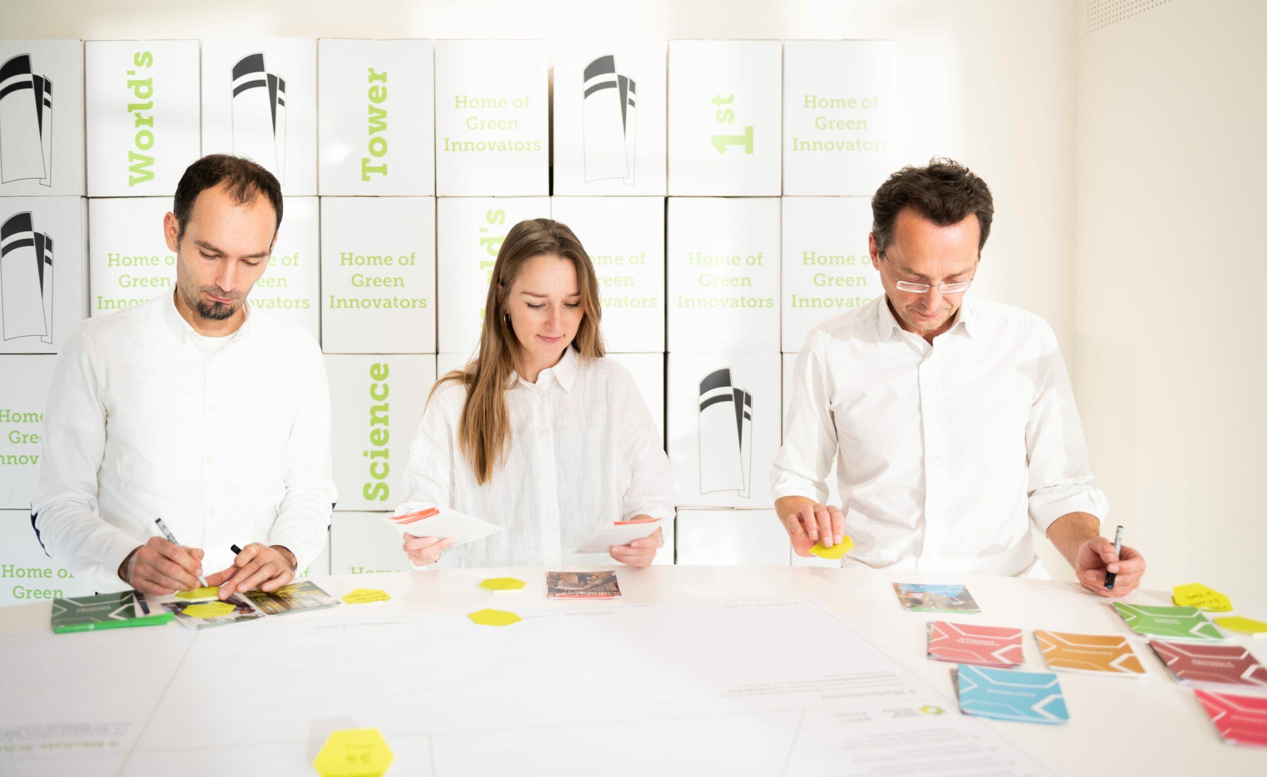 Drei Teammitglieder des Green Tech Valley Clusters arbeiten mit den Green Transformation Cards am Tisch