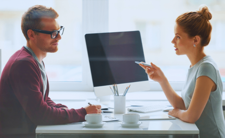 junger mann und junge frau vor bildschirm im gespräch. -c-Canva.com