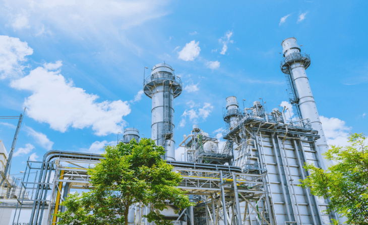 Industrieanlage mit Bäumen im Vordergrund (c) Canva